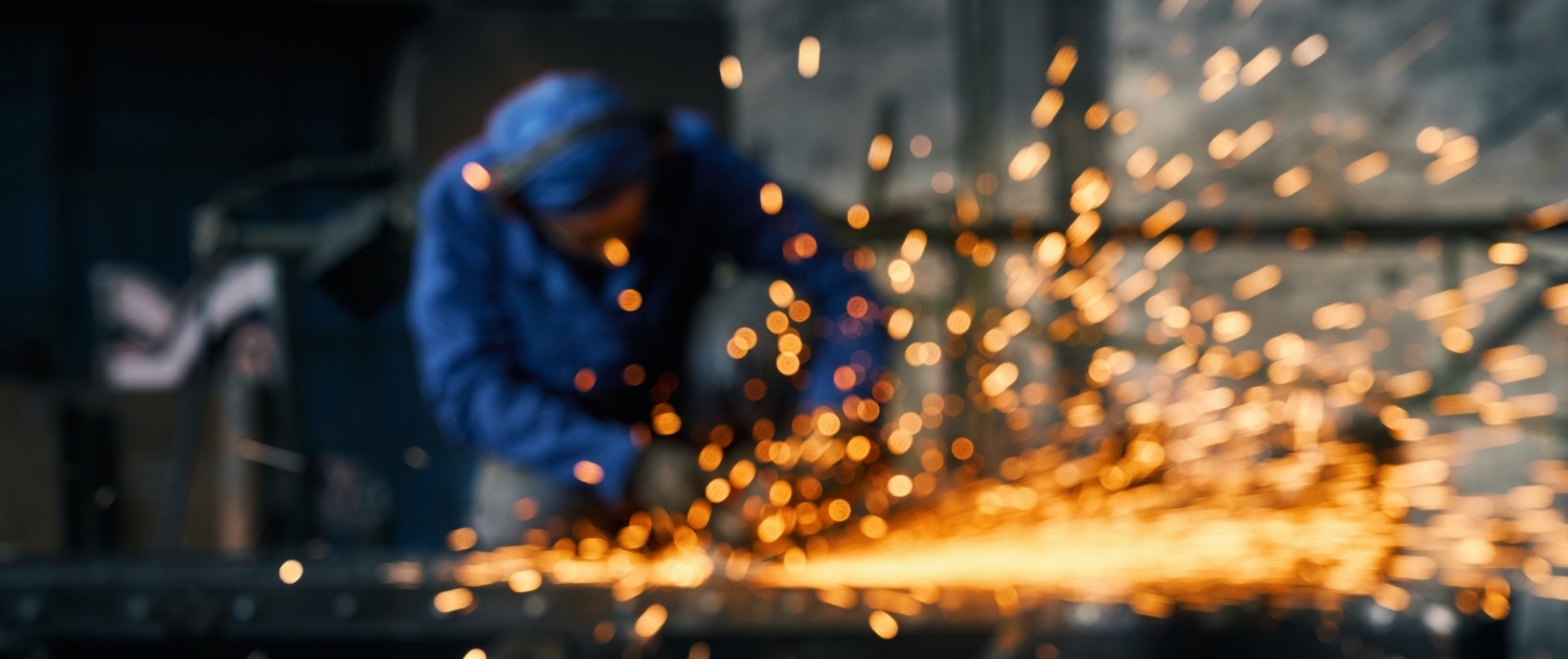 Worker doing gate by electric steel cutter machine.